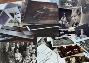 Old family photos strewn across a table surface.